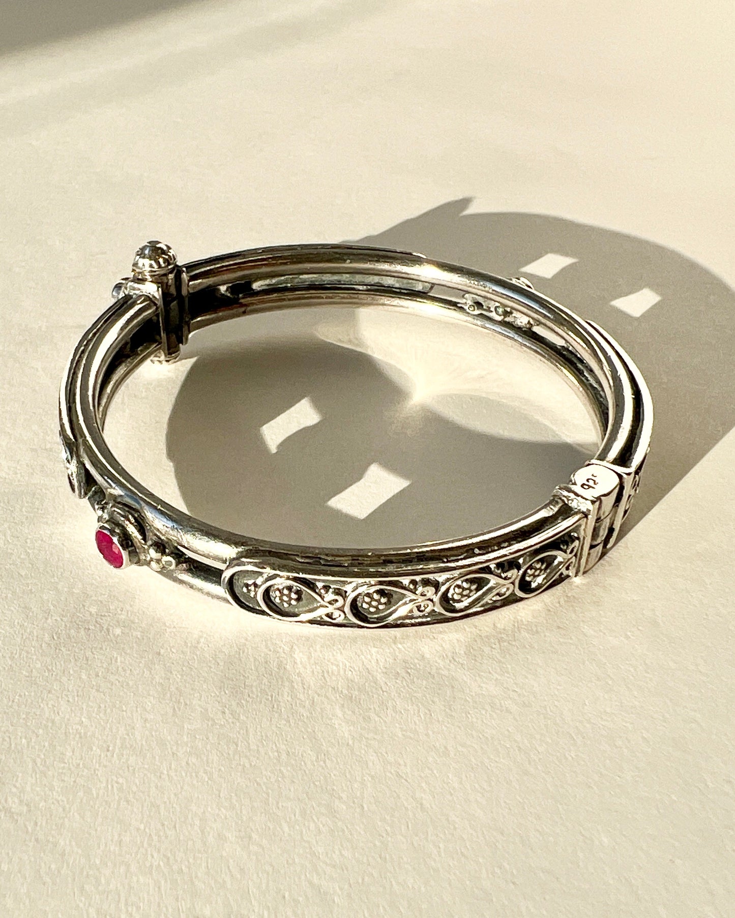 hinged floral bangle with rubies and pin closure