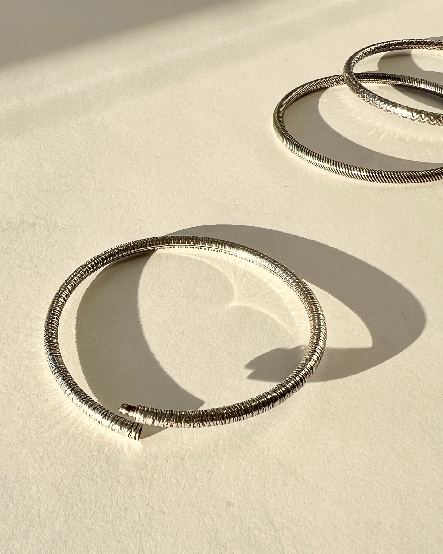 round silver bangles with tension closure