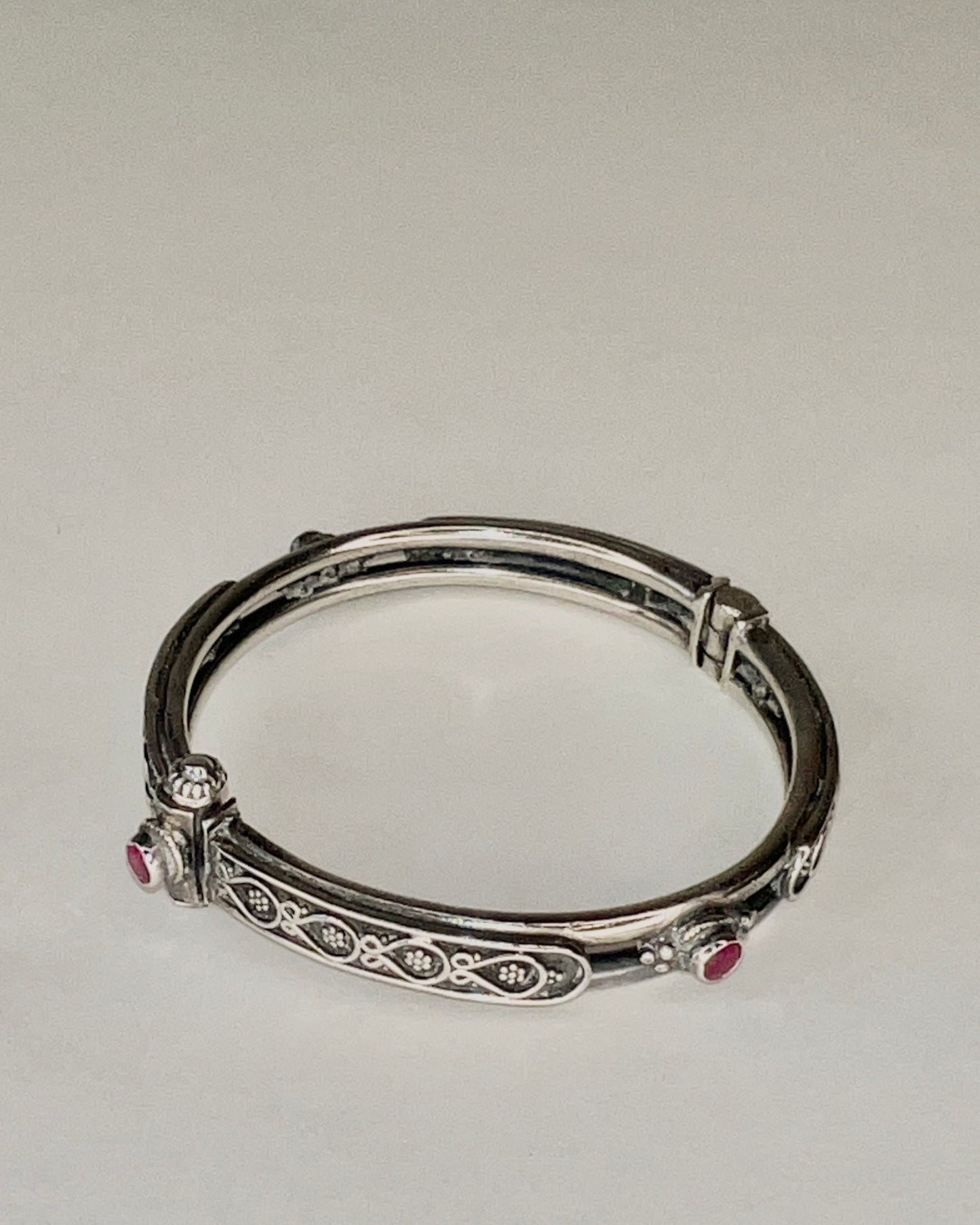 hinged floral bangle with rubies and pin closure